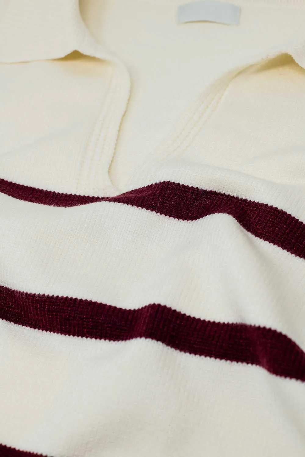 white sweater with dark red stripes and wide v neck